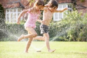 kids summertime fun with sprinklers